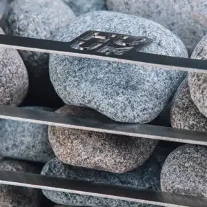 HUUM CLIFF electric sauna heater, close view of rounded stones behind the basket