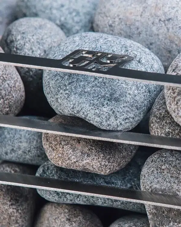 HUUM CLIFF electric sauna heater, close view of rounded stones behind the basket