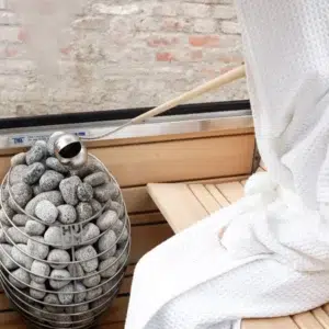 HUUM DROP electric sauna heater, installed beside a sauna bench and window