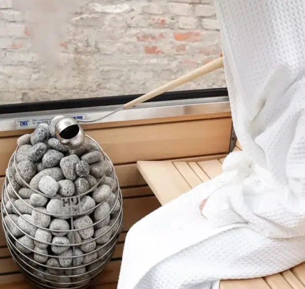 HUUM DROP electric sauna heater, installed beside a sauna bench and window