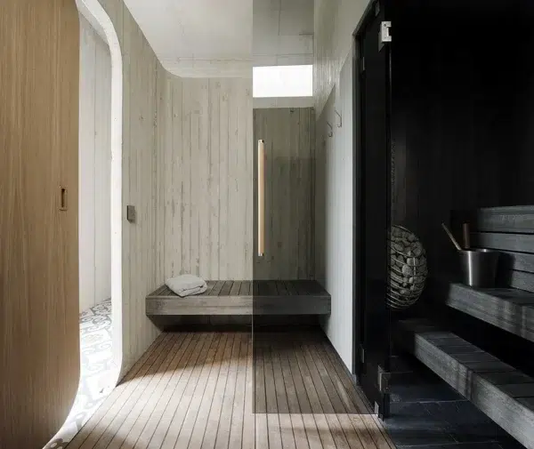 HUUM DROP electric sauna heater, visible through a glass sauna wall