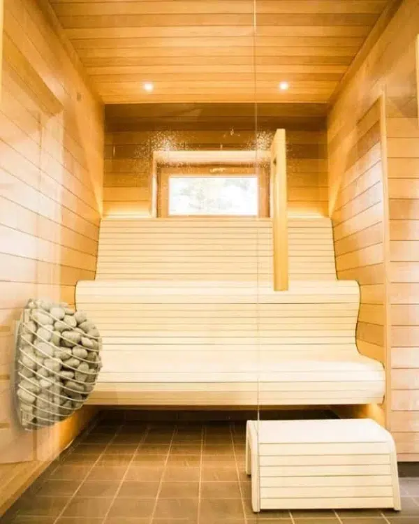 HUUM DROP electric sauna heater, wall-mounted beside pale wooden sauna benches
