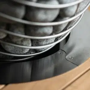 HUUM DROP embedding flange, installed around a heater in a sauna bench