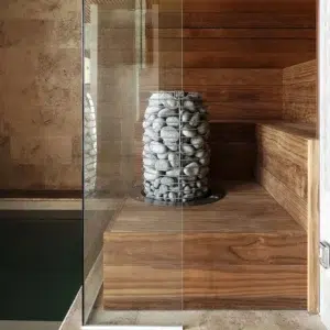 HUUM HIVE Mini electric sauna heater, installed beside a glass sauna door