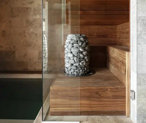 HUUM HIVE Mini electric sauna heater, installed beside a glass sauna door