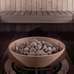 HUUM HIVE sauna heater safety railing, installed around a stone-filled heater below sauna benches
