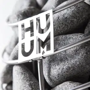 HUUM sauna stones, HUUM logo in front of stacked sauna stones