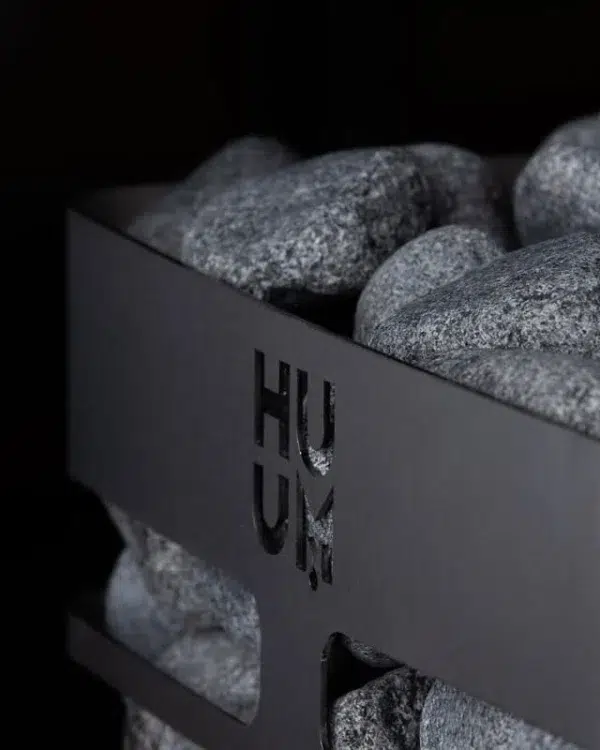 HUUM steel electric sauna heater, close view of top stones and HUUM badge