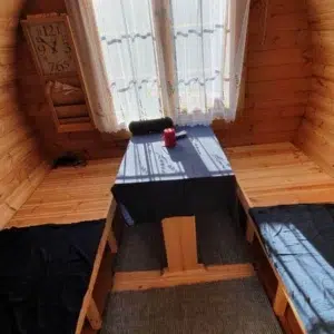 Outdoor barrel sauna, changing-room table and benches beneath a window