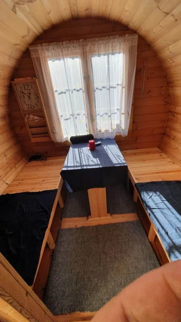 Outdoor barrel sauna, changing-room table and benches beneath a window