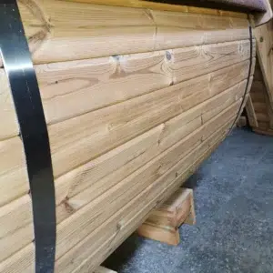 Outdoor barrel sauna, detail of curved wooden cladding and metal band