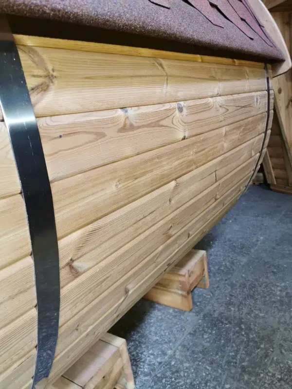 Outdoor barrel sauna, detail of curved wooden cladding and metal band