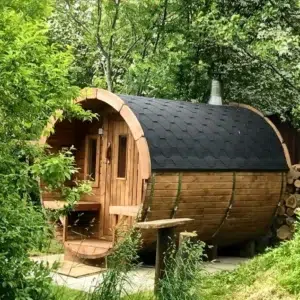 Outdoor barrel sauna, exterior among leafy trees