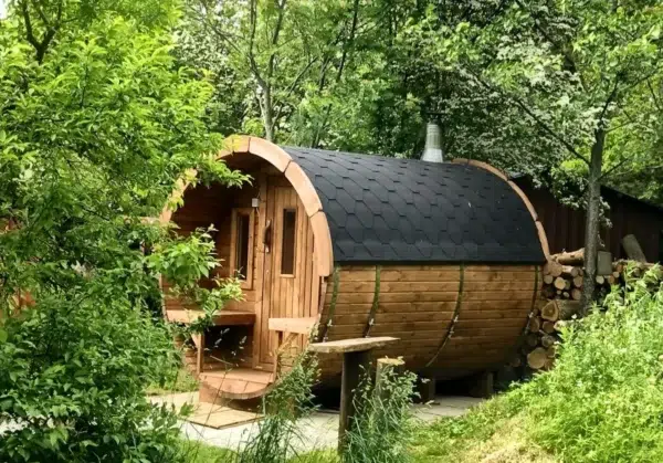 Outdoor barrel sauna, exterior among leafy trees
