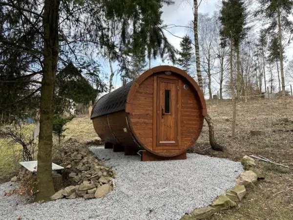 Outdoor barrel sauna, exterior on a gravel pad among trees