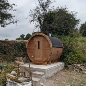 Outdoor barrel sauna, exterior on a raised concrete base