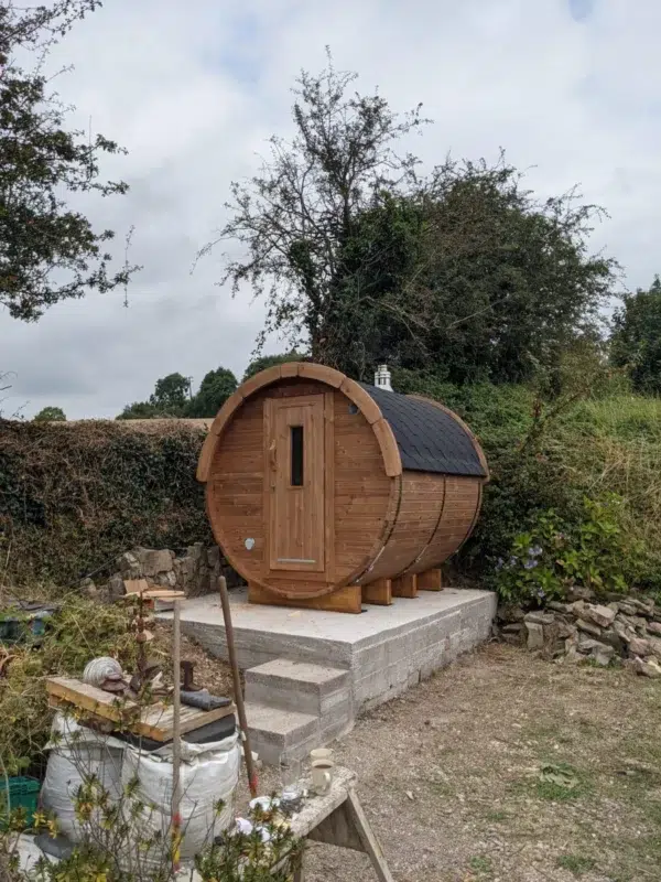 Outdoor barrel sauna, exterior on a raised concrete base