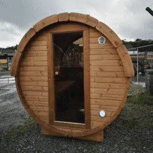 Outdoor barrel sauna, front exterior with a glass entrance door
