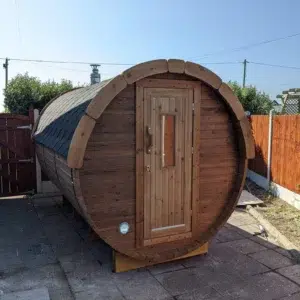 Outdoor barrel sauna, front exterior with wooden entrance door
