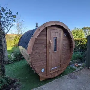 Outdoor barrel sauna, front and side exterior in a garden