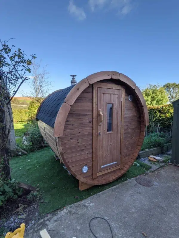Outdoor barrel sauna, front and side exterior in a garden