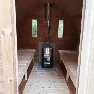 Outdoor barrel sauna, interior aisle with opposing benches and stove