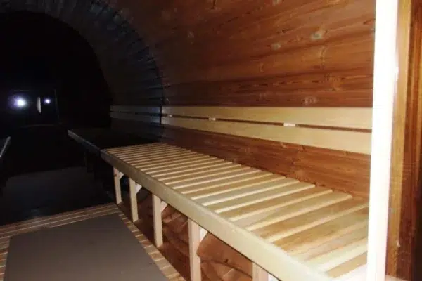 Outdoor barrel sauna, interior bench beside panoramic glazing