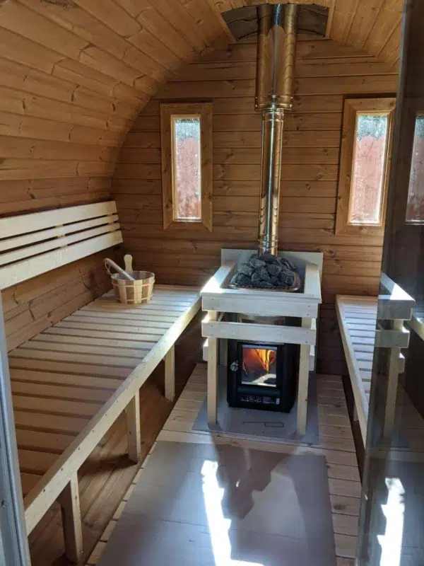 Outdoor barrel sauna, interior benches around a wood-burning stove