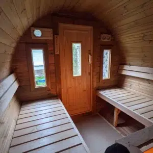 Outdoor barrel sauna, interior benches facing the entrance door