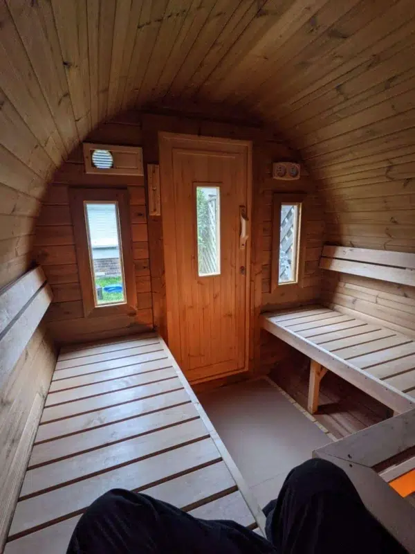 Outdoor barrel sauna, interior benches facing the entrance door