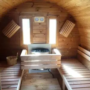 Outdoor barrel sauna, interior benches surrounding a wood-burning stove