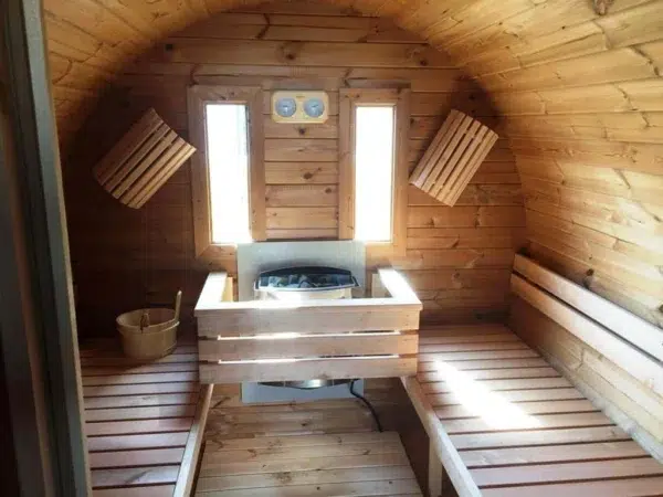 Outdoor barrel sauna, interior benches surrounding a wood-burning stove