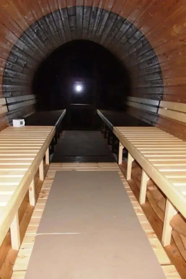 Outdoor barrel sauna, interior with opposing benches and dark panoramic window
