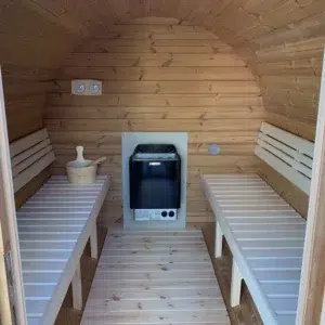 Outdoor barrel sauna, interior with opposing benches and electric heater