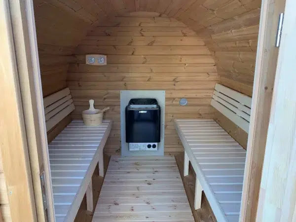 Outdoor barrel sauna, interior with opposing benches and electric heater