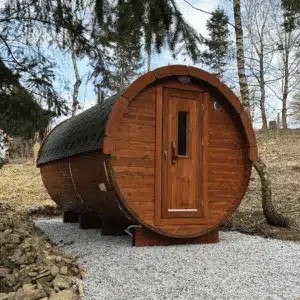 Outdoor barrel sauna without a porch, front exterior beside trees