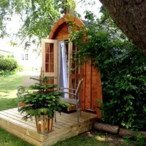Outdoor pod sauna, front entrance on a wooden deck