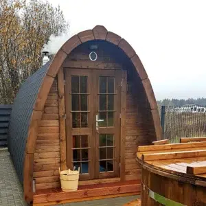 Outdoor pod sauna, front exterior beside a wooden hot tub
