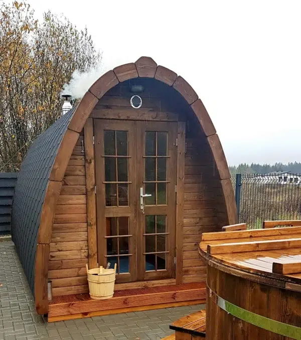 Outdoor pod sauna, front exterior beside a wooden hot tub