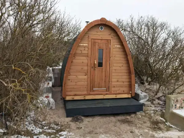 Outdoor pod sauna, front exterior on a raised base