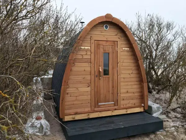 Outdoor pod sauna, front exterior with wooden entrance door