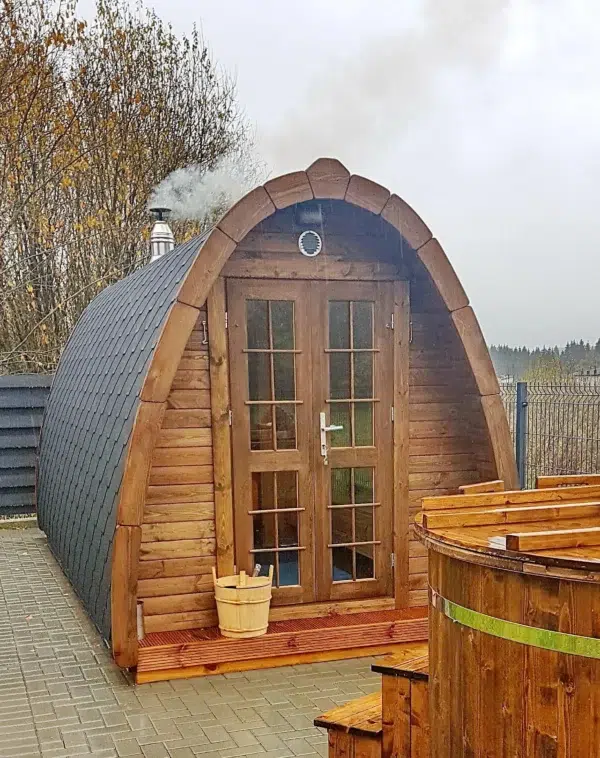 Outdoor pod sauna, front and side exterior beside a hot tub