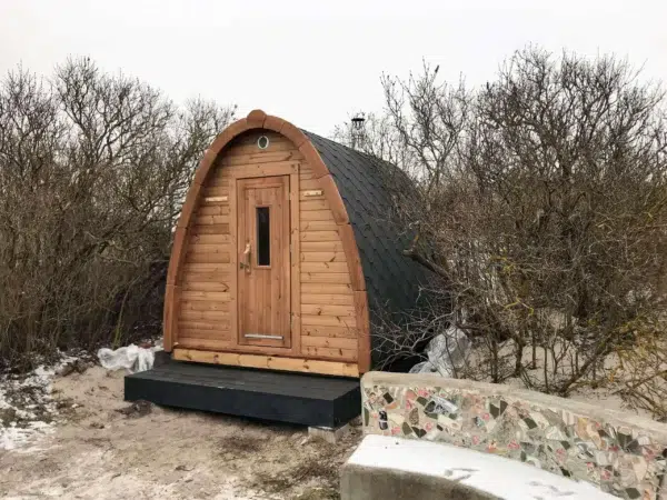 Outdoor pod sauna, front and side exterior on a raised base