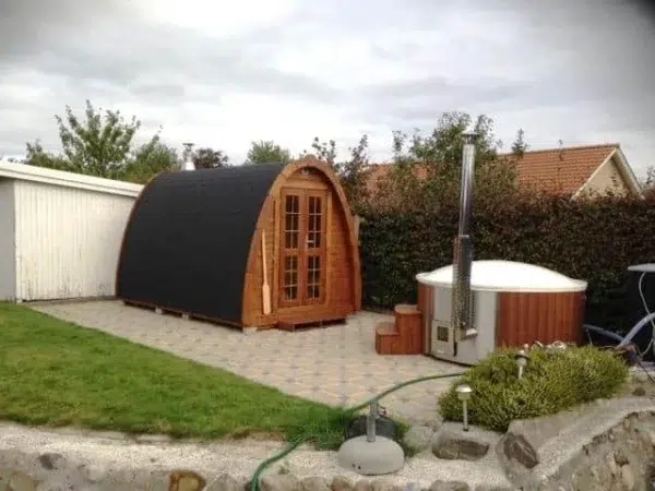 Outdoor pod sauna, garden installation beside an outdoor hot tub