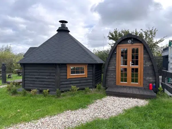 Outdoor pod sauna, garden installation beside a separate hut