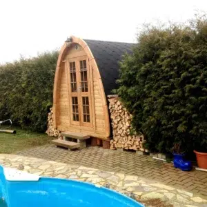 Outdoor pod sauna, garden installation beside a swimming pool