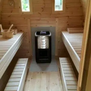 Outdoor pod sauna, interior benches beside a wood-burning stove