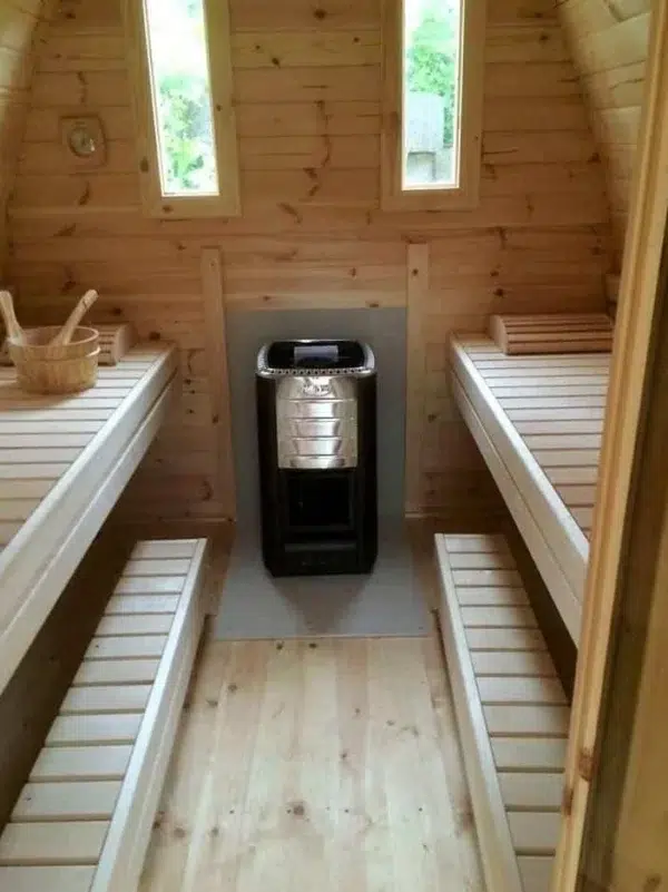 Outdoor pod sauna, interior benches beside a wood-burning stove