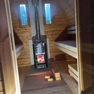 Outdoor pod sauna, interior with lit wood-burning stove