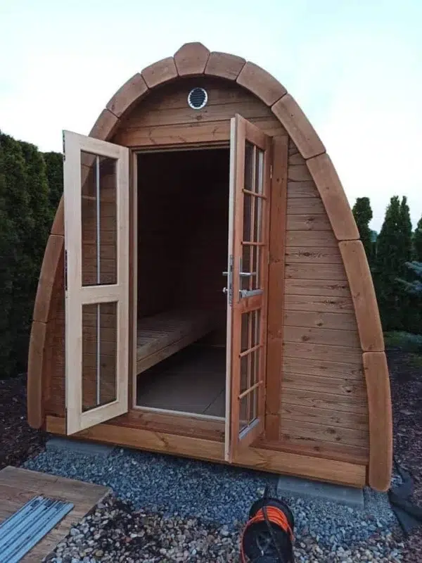 Outdoor pod sauna, open double doors showing wooden interior